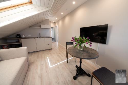 a living room with a table with flowers on it at COME2rest - Smilga in Juodkrantė