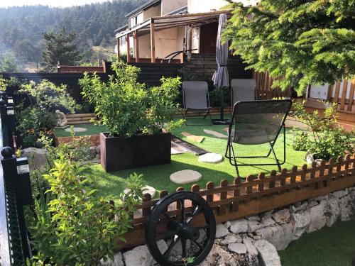 a garden with a fence and a lawn with chairs at Location Studio avec Jardin en Hameau II in Gréolières