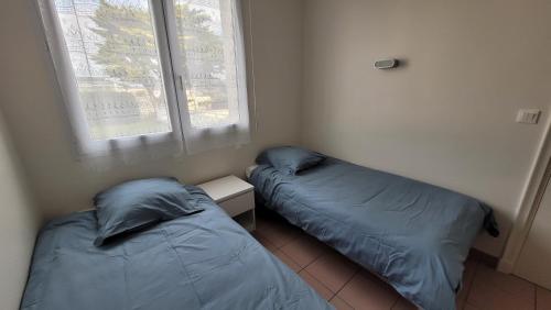 Duas camas num pequeno quarto com uma janela em T3 “Groix“- 50 m de la plage de Fort Bloqué/Ploemeur em Ploemeur