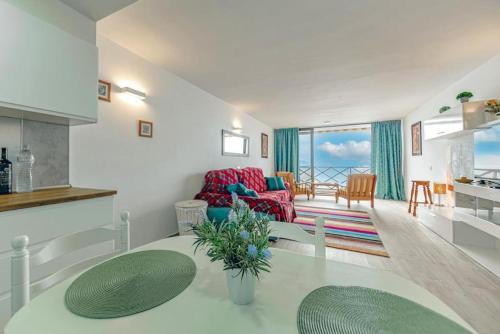 een woonkamer met een bank en een tafel bij Ocean View Suite with beach private access in Puerto de Santiago