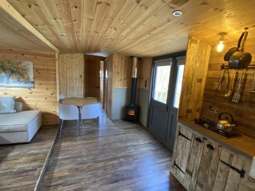 Zimmer mit einem Bett und einem Tisch in einer Hütte in der Unterkunft Fairwood Lakes Holiday Park in Westbury