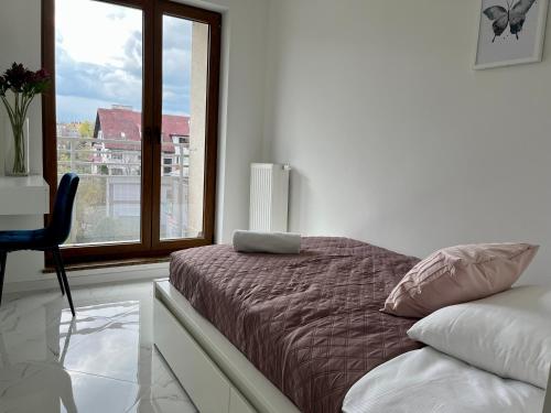 sypialnia z łóżkiem i dużym oknem w obiekcie Apartament Charlotte Link w Jeleniej Górze