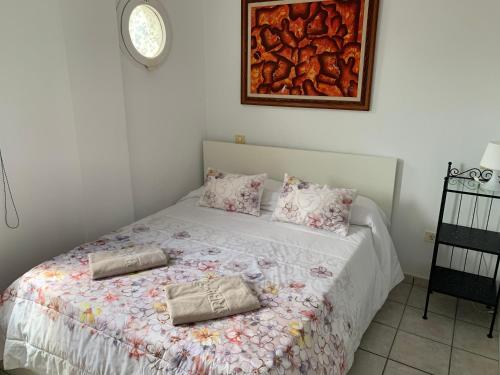 a bedroom with a bed with a floral bedspread at Mar Azul Arinaga in Arinaga