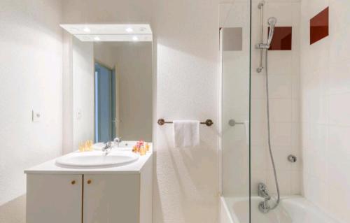 une salle de bain blanche avec un lavabo et une douche dans l'établissement Les Terrasses du Lac piscine M65, à Aureilhan