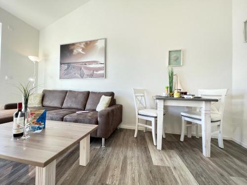 - un salon avec un canapé et une table dans l'établissement ZUM LEUCHTTURM Wellness-Appartement APPARTO Grömitz, à Grömitz