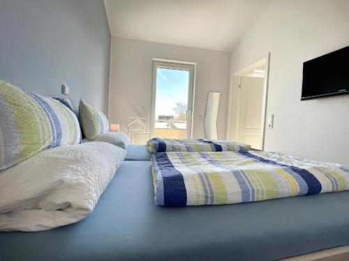 a bedroom with two pillows on a blue bed at ZUM LEUCHTTURM Wellness-Appartement APPARTO Grömitz in Grömitz