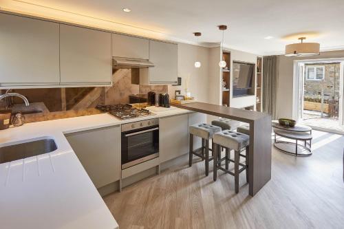 a kitchen with white cabinets and a stove top oven at Host & Stay - Priory Yard, Barnard Castle in Barnard Castle