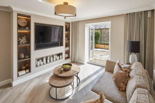a living room with a couch and a tv at Host & Stay - Priory Yard, Barnard Castle in Barnard Castle