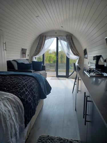 a bedroom with a bed and a desk and a window at Parcglas - Hazel in St Clears