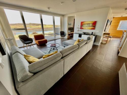 a large living room with a large couch and chairs at Brún in Laugaras