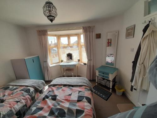 a bedroom with two beds and a desk and a window at The Homestay Get Away in Kent