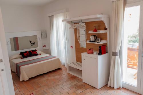 1 dormitorio con 1 cama en una habitación con ventana en Da Fede, en Capo Testa