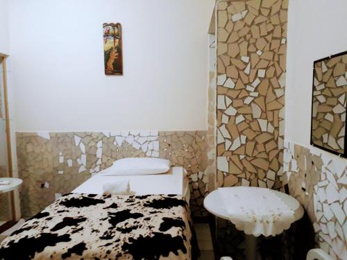 a small room with a bed and a stool at RESIDENCIAL OLIVEIRA in Manaus