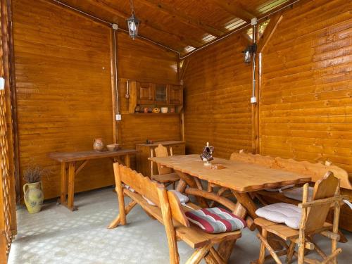 Habitación de madera con mesa y sillas de madera en Casa Neluta, en Haţeg