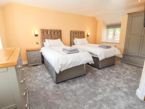 two beds in a room with yellow walls at Nant Y Celyn in Ruthin
