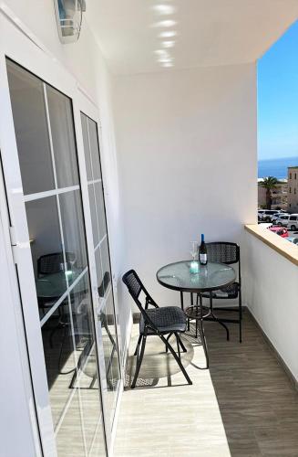 a table and chairs in a room with a balcony at Casa Filo, maravilloso apartamento en Morro Jable in Morro del Jable