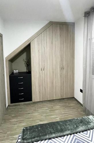 una camera da letto con armadi in legno e cassettiera di Casa Filo, maravilloso apartamento en Morro Jable a Morro del Jable