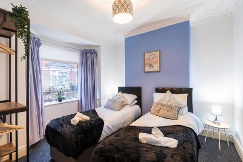 two beds in a room with blue walls at Contractor and Family House & Free Parking & Garden in Hull