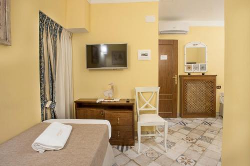 a hotel room with a bed and a desk and a television at Dependance in Naples