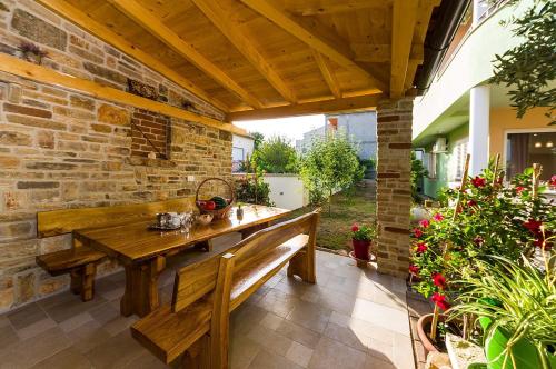 a patio with a wooden bench and a brick wall at Apartmani Vanja in Zadar