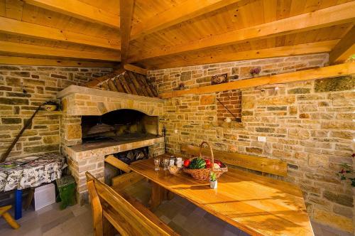 a kitchen with a wooden table and a brick wall at Apartmani Vanja in Zadar