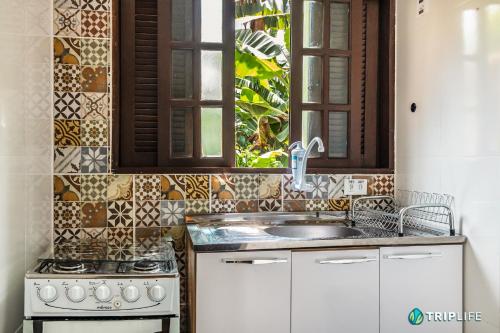 uma cozinha com um lavatório e um fogão em Chalés da Libélula em Ilhabela