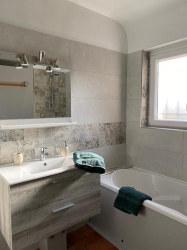 La salle de bains est pourvue d'un lavabo, d'une baignoire et d'une fenêtre. dans l'établissement La Valinière, à Seur