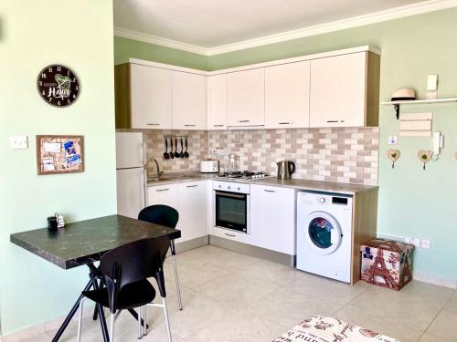 een keuken met een tafel en een wasmachine bij Relax studio, "Park Residence" in Trikomo