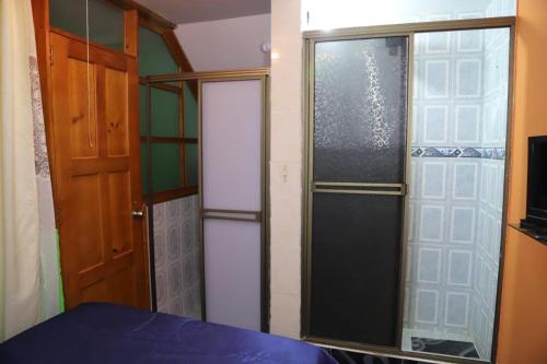una habitación con dos puertas de cristal y una cama en ella en Hotel la Cabaña, en El Cocuy