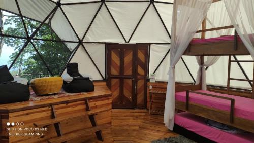 a room with a wooden table and a wooden bench at Trekker Glamping in Minca