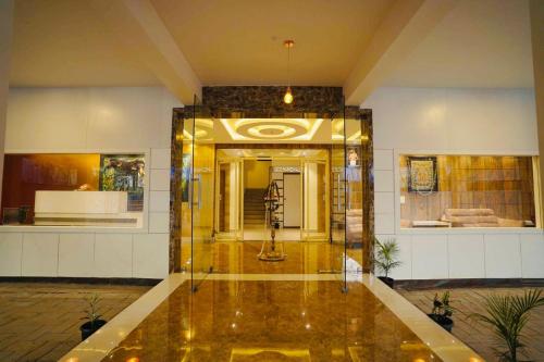 a lobby with a glass elevator in a building at Geetha Govindham in Guruvāyūr
