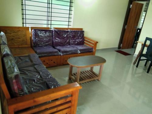 - un salon avec un canapé et une table dans l'établissement SAMZ ESTATE Stay 3BHK, à Madikeri