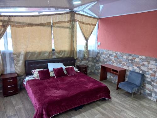 a bedroom with a purple bed and a blue chair at Hostal La Casa De Rodrigo in Baeza