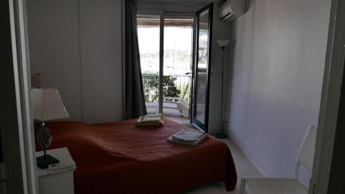 une chambre avec un lit et une grande fenêtre dans l'établissement LA GALIOTTE SUR LE GOLFE DE ST TROPEZ, à Cogolin