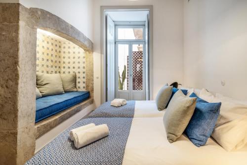 a bedroom with a large bed and a blue couch at Beautiful Apartment close to Praça do Comércio by LovelyStay in Lisbon