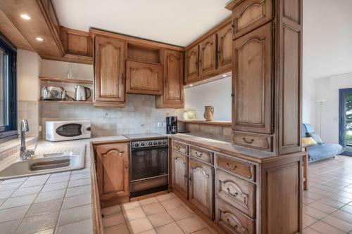 une cuisine avec des armoires en bois et un évier dans l'établissement Vacances au plus proche de la Petite Mer, à Arzon