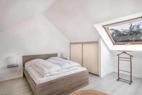 a bedroom with a large bed with a skylight at Vacances au plus proche de la Petite Mer in Arzon