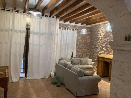 a living room with a couch and white curtains at Town House Ca Na Mabel in Sa Pobla in Sa Pobla
