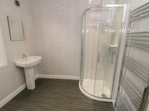 a bathroom with a shower and a sink at Ashben Cottage in Whitby