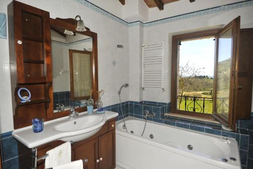a bathroom with a tub and a sink and a mirror at Villa Alice in Chiusi