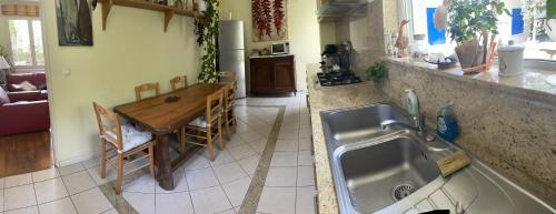 - une cuisine avec un évier et une table dans l'établissement Charmante villa au Cap Ferret à 2 pas du Bassin, à Lège-Cap-Ferret