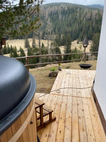 a wooden deck with a table and bench on a balcony at Almhaus Zirbenheim Nicolina in Flattnitz