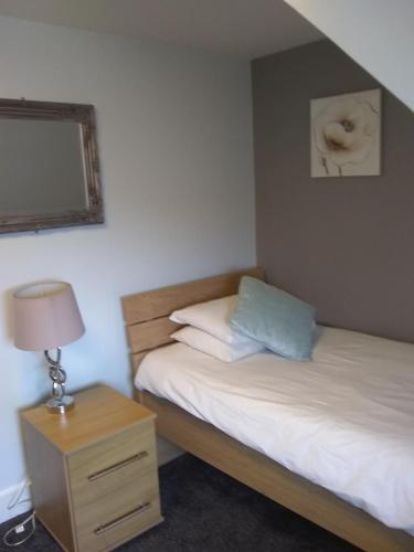 a bedroom with two beds and a lamp and a mirror at White Horse Hotel in Strichen