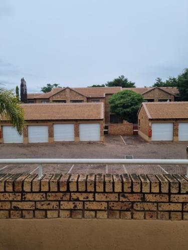 a brick wall in front of some buildings at Home away from home in Centurion