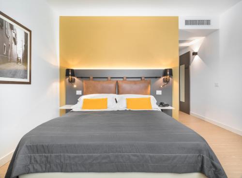 a bedroom with a large bed with orange pillows at Rivalta Life Style Hotel in Salò