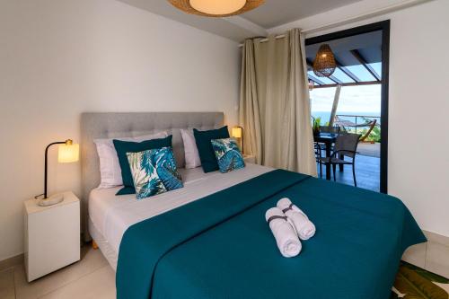 a bedroom with a bed with two pairs of shoes on it at DHM - Domaine Habitation Merveilleuse in La Trinité