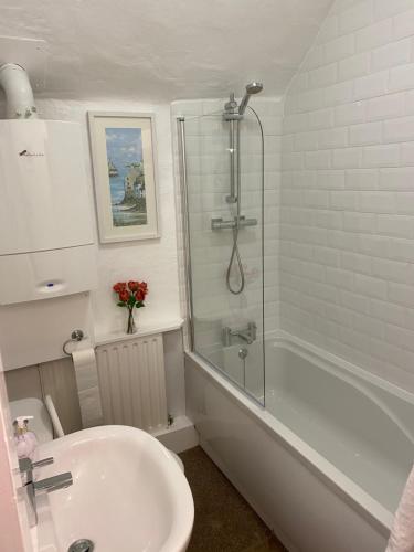 a bathroom with a shower and a sink and a tub at Primrose cottage in Tideswell