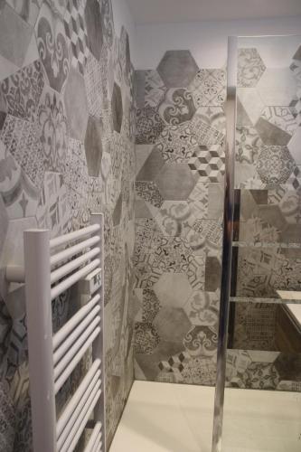 La salle de bains est pourvue d'une douche et d'un mur en pierre. dans l'établissement Studio ISARD, wifi et parking gratuit, Navette gratuite au pied de la résidence, possibilité forfait ménage et location linge de lit et toilette, à 10 minutes à pied du centre ville, à Font-Romeu-Odeillo-Via