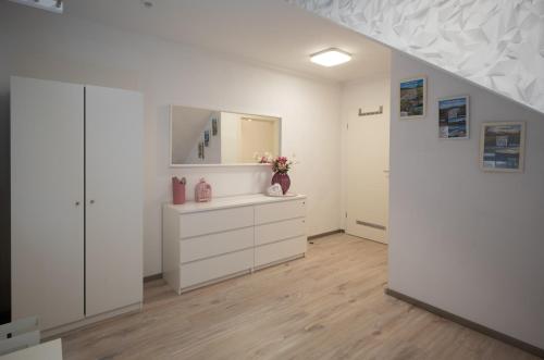 ein weißes Badezimmer mit einer Kommode und einem Spiegel in der Unterkunft Ferienwohnung Ronja in Beckingen