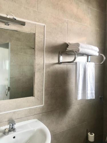 La salle de bains est pourvue d'un lavabo, d'un miroir et de serviettes. dans l'établissement Arcada House Tavira, à Tavira